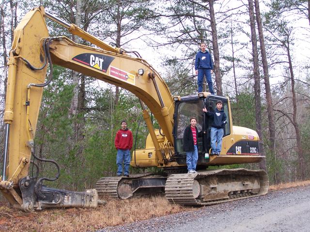 Michael, Austin, Dustin & Josh Standing On The Trackhoe That Was Used To Fix The Road Back To Litte Dugger Creek, It Was Was