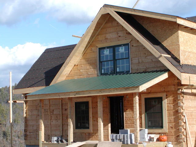 Front View As Roofers Are Putting On The Tin Roof